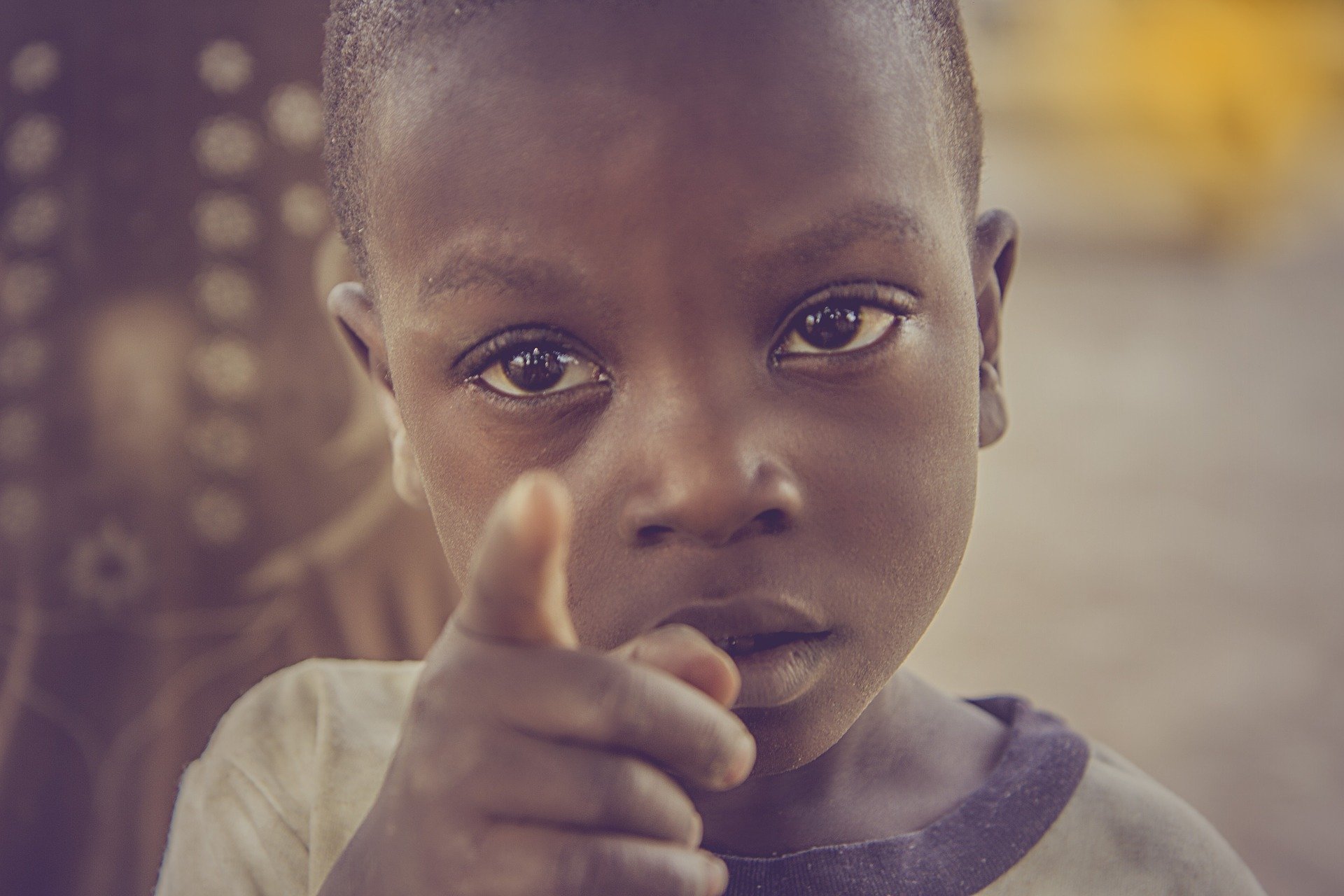 Ein afrikanisches Kind der nach Kamera zeigt