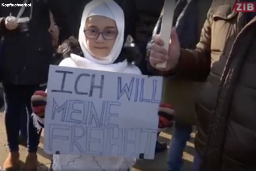 Ein Mädchen mit Hijab mit dem Schild: ich will meine Freiheit