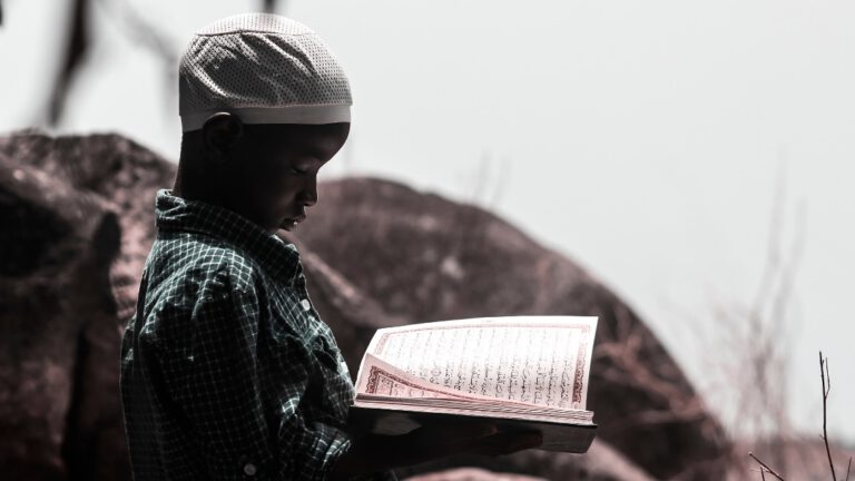 Kind liest Koran in der Wüste