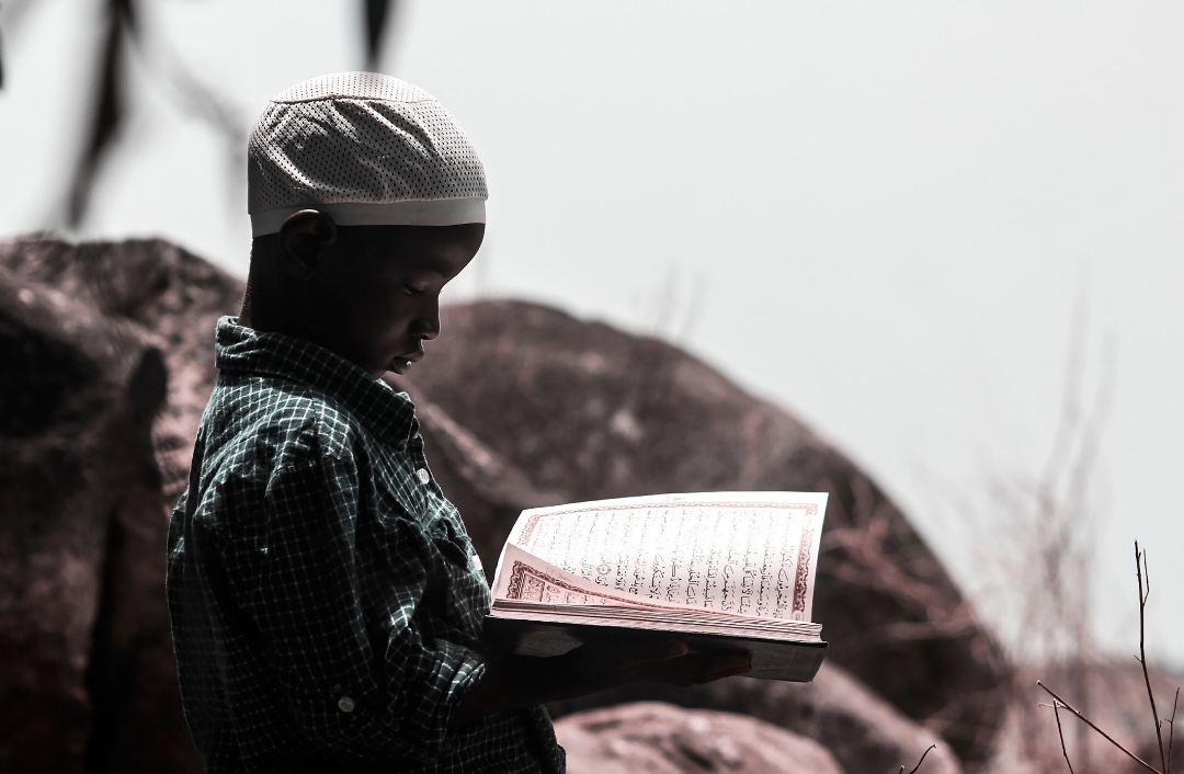Kind liest Koran in der Wüste